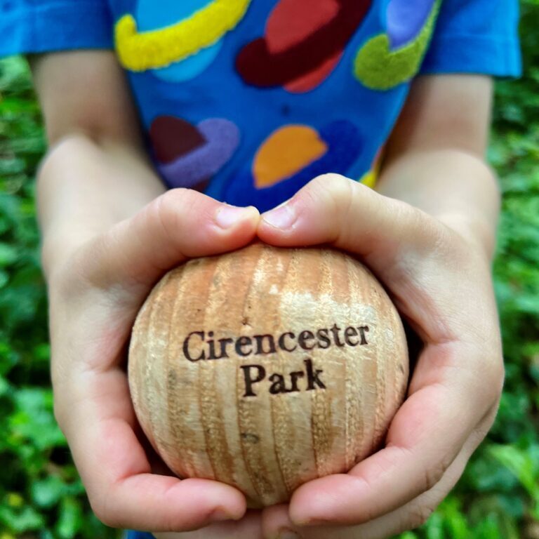 Child holding ball in Cirencester Park